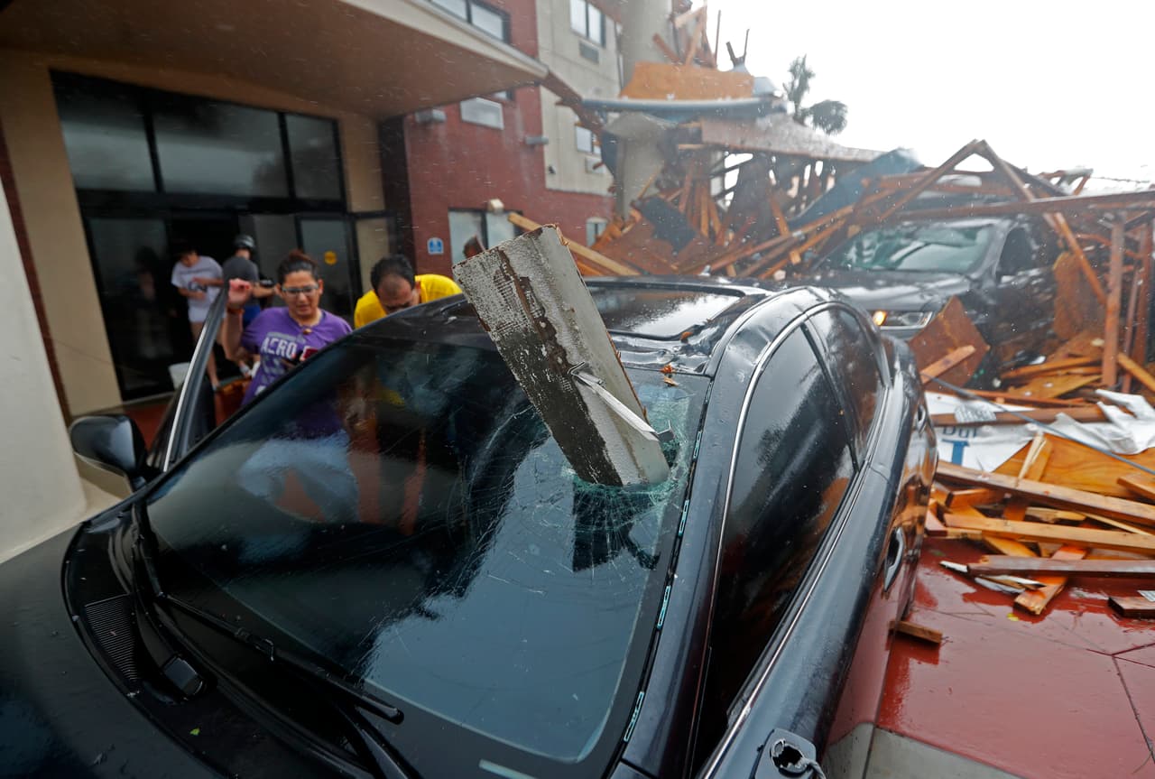 Un residente explora su vehículo impactado por los escombros impulsados por el huracán. El ojo pasó muy cerca de Panama City, Florida, donde ha causado destrozos.