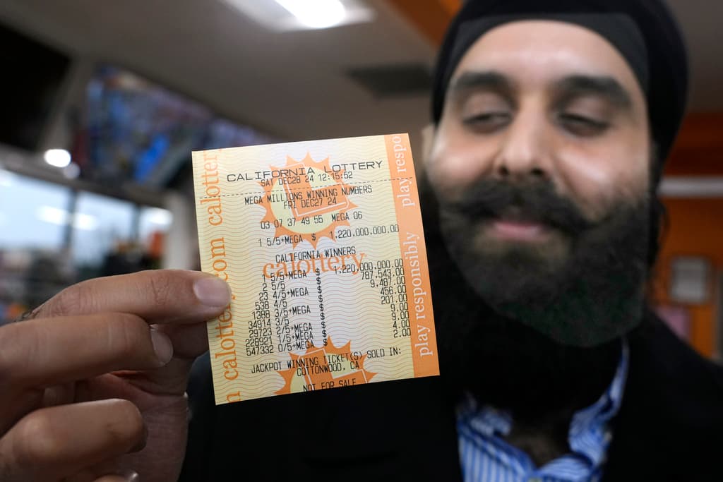 Ishar Gill, director de operaciones del negocio familiar 
<b>Circle K (o Sunshine Food and Gas) </b>presumió este sábado, 28 de diciembre, la certificación de parte de la 
<b><a href="https://www.univision.com/local/nueva-york-wxtv/loteria-nueva-york/mega-millions-premio-mayor-nueva-jersey-1-130-millones-reclama-premio-marzo-9-meses-despues" target="_blank">lotería electrónica de Mega Millions</a></b> sobre los boletos ganadores del sorteo del viernes 27. Gill sonríe porque alguien que compró el boleto en el establecimiento de su familia, ganó 
<b>$1,220 millones</b>.