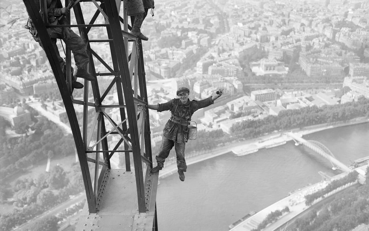 Una foto de 1924 que muestra a obreros trabajando en la Torre Eiffel para volver a pintar la gran estructura de acero. La Torre Eiffel tiene 984 pies de altura y consiste en un armazón de hierro apoyado en cuatro pilares desde donde se alzan cuatro columnas que se unen para formar una sola torre vertical. 
<br>
