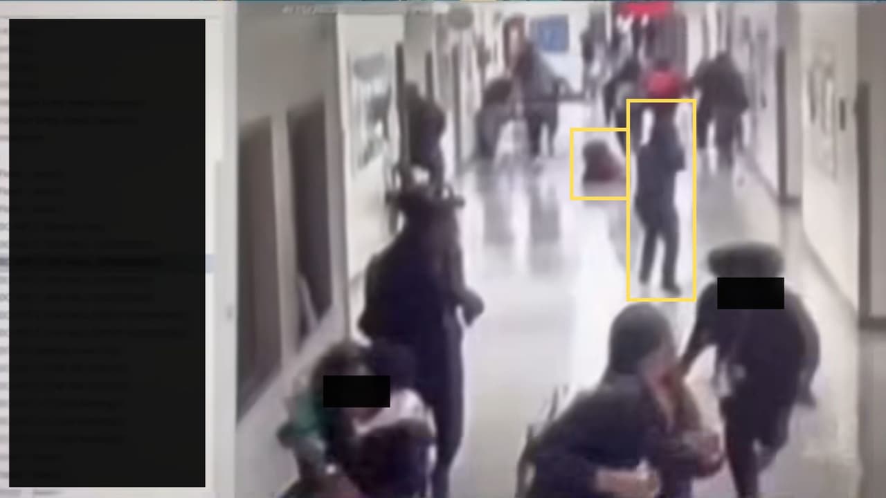 Los alumnos huyen del lugar, cuando 
<b>uno de ellos cae al suelo</b>, a solo unos pasos del joven con capucha, que 
<b>continúa apuntando al grupo.</b>