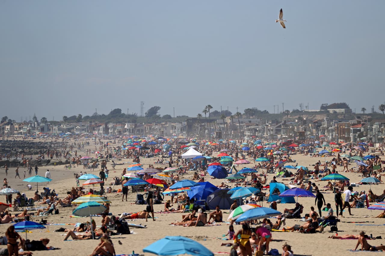 Estas aglomeraciones ocurrieron en una playa cerca del muelle de 
<b><a href="https://www.univision.com/local/los-angeles-kmex/si-estas-fotos-son-de-este-sabado-en-california-te-explicamos-por-que">Newport Beach,</a></b> donde autoridades locales autorizaron el acceso al público, con la recomendación de respetar la distancia social, debido a la ola de calor que experimenta la región.