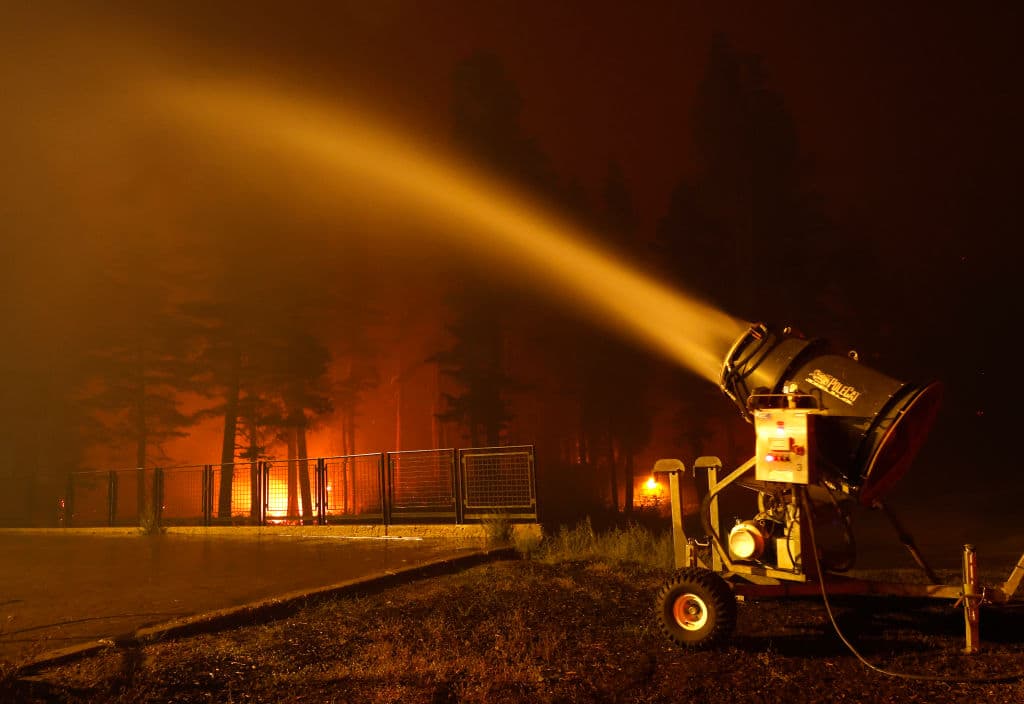 Empleados utilizaron máquinas que convierten el agua a nieve para remojar estructuras y el bosque alrededor del parque para esquiar para prevenir que estos se prendan en fuego.