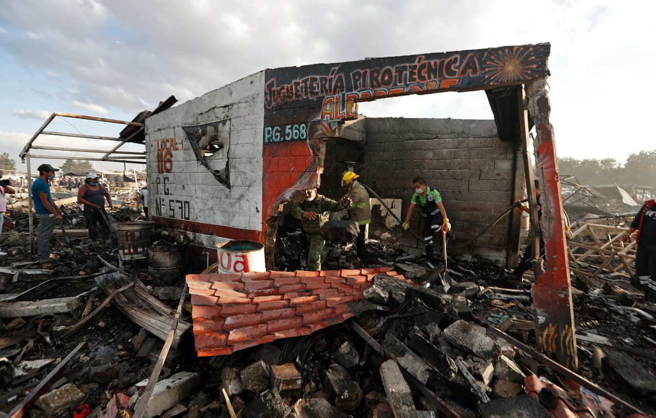 Bomberos y rescatistas remueven los escombros en algunos de los locales que resultaron devastados tras la explosión.
