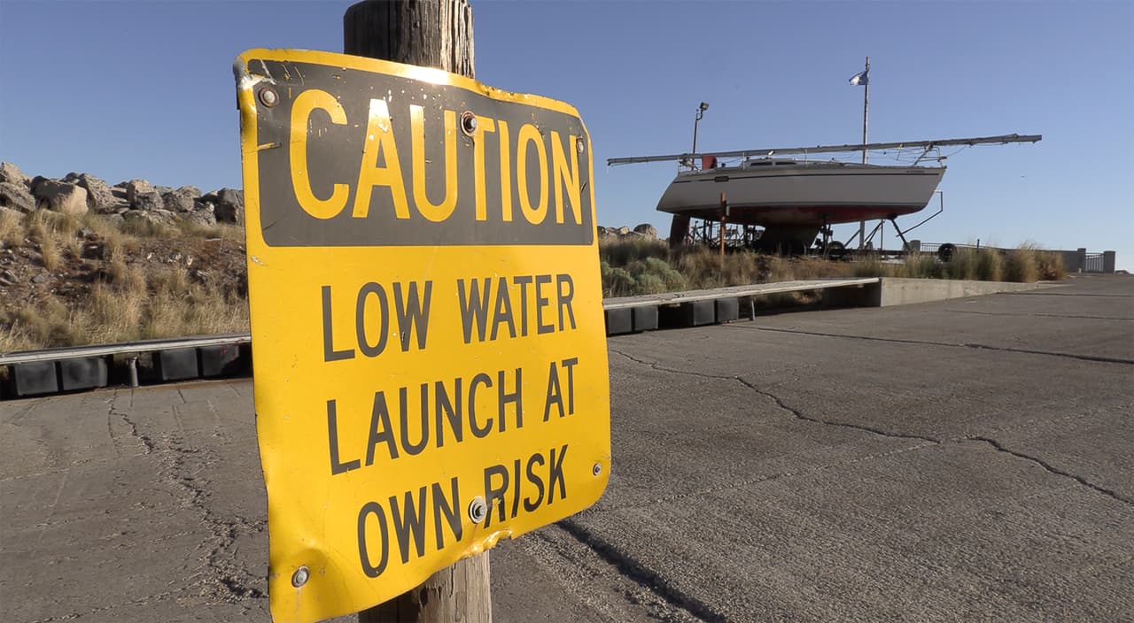En esta imagen del 3 de junio de 021, la señal en la Marina Great Salt Lake cerca de Salt Lake City advierte "CUIDADO AGUA BAJA LANCE SU EMBARCACIÓN A SU PROPIO RIESGO" .