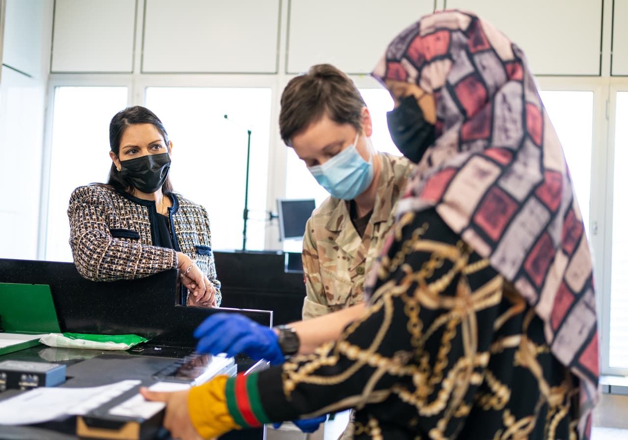 La secretaria de interior de Reino Unido, Priti Patel, observa la entrada al país de una refugiada afgana en el aeropuerto Heathrow de Londres, el 26 de agosto.
<br>
<br>El Reino Unido anunció que aceptará 20,000 refugiados afganos a largo plazo. El plan del gobierno británico está enfocado 
<a href="https://www.theguardian.com/world/2021/aug/17/uk-to-take-20000-afghan-refugees-over-five-years-under-resettlement-plan"><u>en las mujeres y los niños</u></a> y permitirá que 5,000 afganos se establezcan en el país en el primer año.