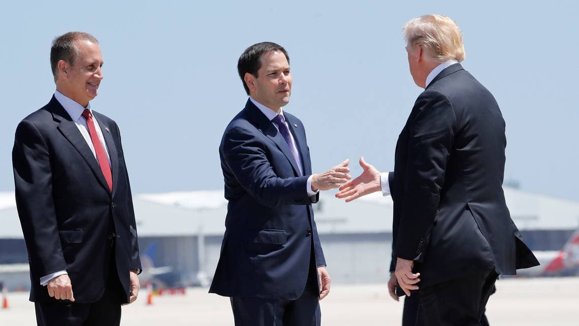 President Trump is greeted by Sen. Marco Rubio, as Rep. Mario Diaz-Balart, R-Fla., looks on at Miami International Airport, Monday April 16, 2018.
