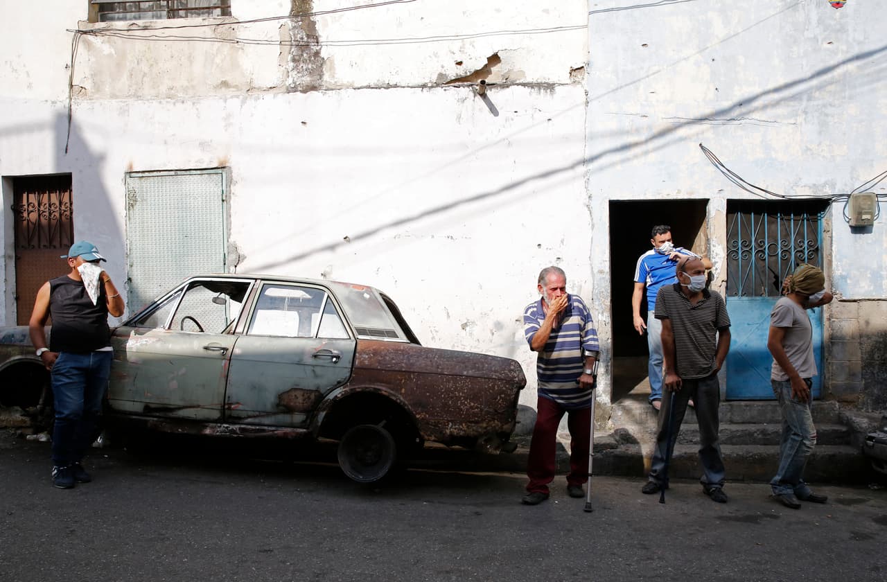 Un grupo de vecinos de Cotiza se tapa la nariz para evitar respirar los gases lacrimógemos lanzados por los efectivos de seguridad.