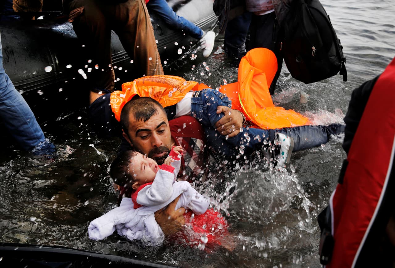 <b>A salvo en Grecia. </b>Un refugiado sirio que huyó de la guerra civil de su país, ayuda a sus dos hijos a alcanzar la costa en Lesbos, Grecia. 12 de octubre de 2016.
<b> </b>