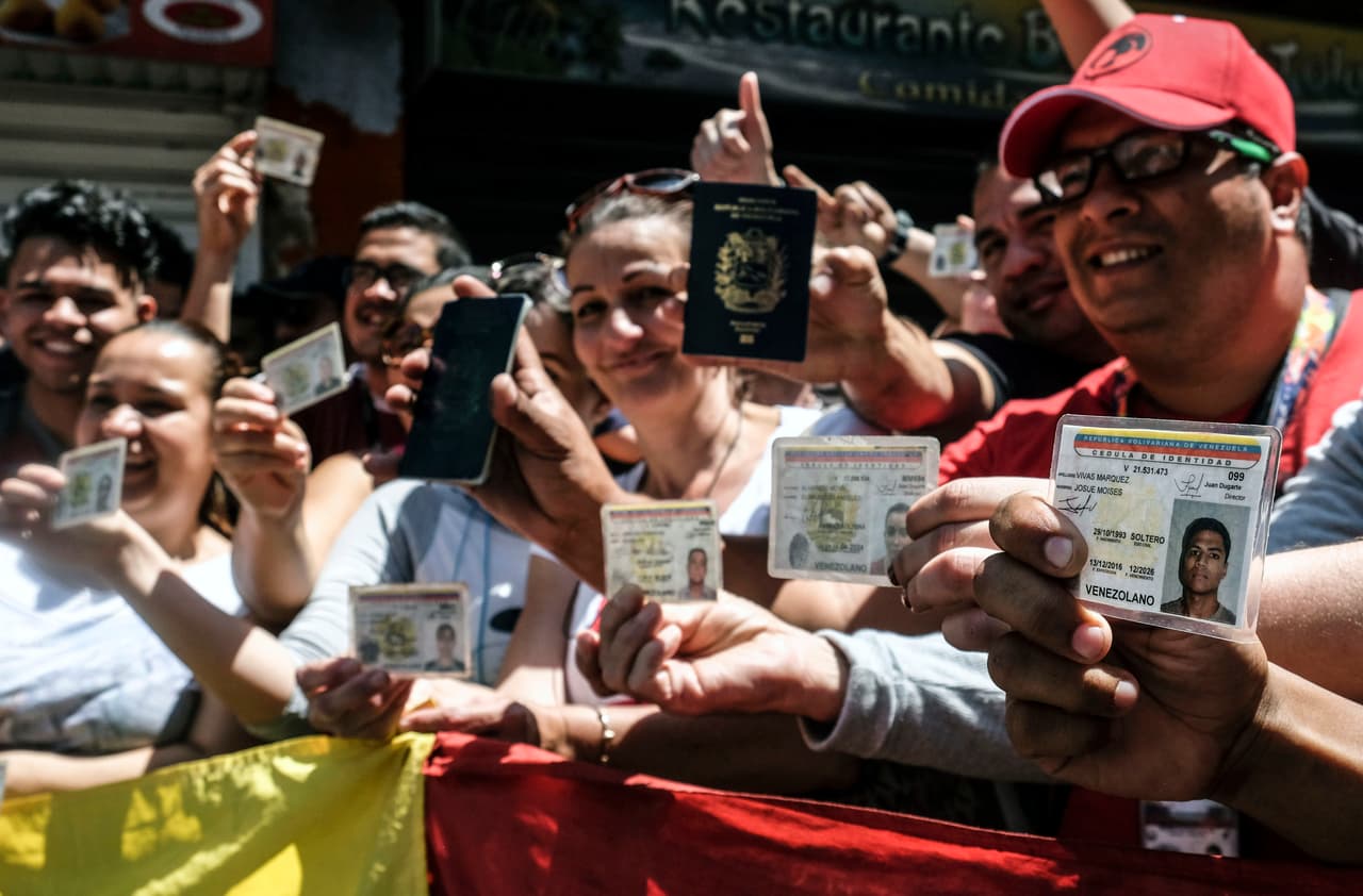 Varios votantes muestran sus documentos venezolanos en Bogotá, Colombia.