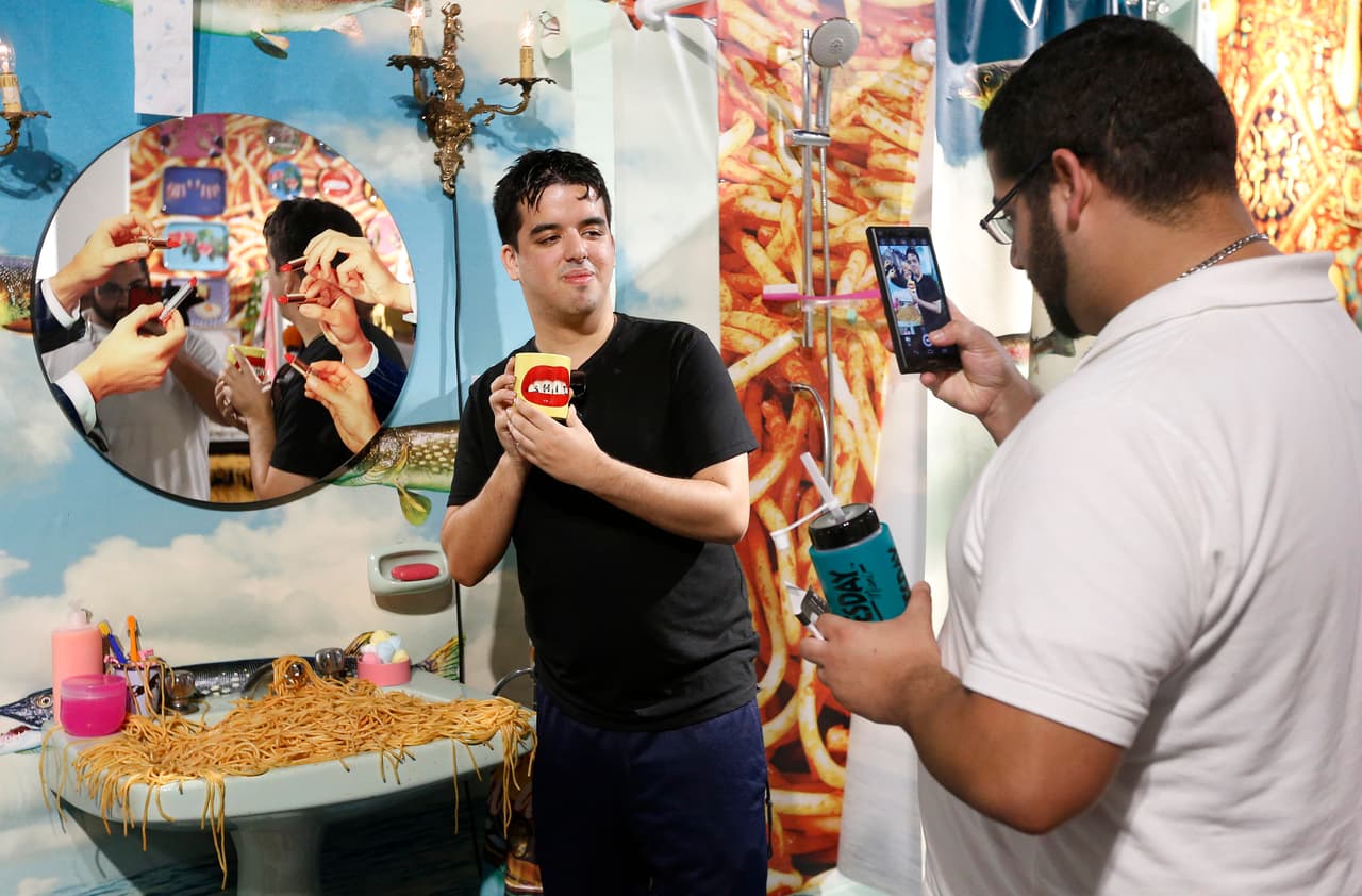 Art patrons take photographs with the art from The Fondation Beyeler gallery during Art Basel in Miami on November 30, 2016. Art Basel represents over 250 art galleries at the Miami Beach Convention Center and is considered one of the world's largest art festivals with art events throughout the city. / AFP / RHONA WISE / RESTRICTED TO EDITORIAL USE - MANDATORY MENTION OF THE ARTIST UPON PUBLICATION - TO ILLUSTRATE THE EVENT AS SPECIFIED IN THE CAPTION (Photo credit should read RHONA WISE/AFP/Getty Images)