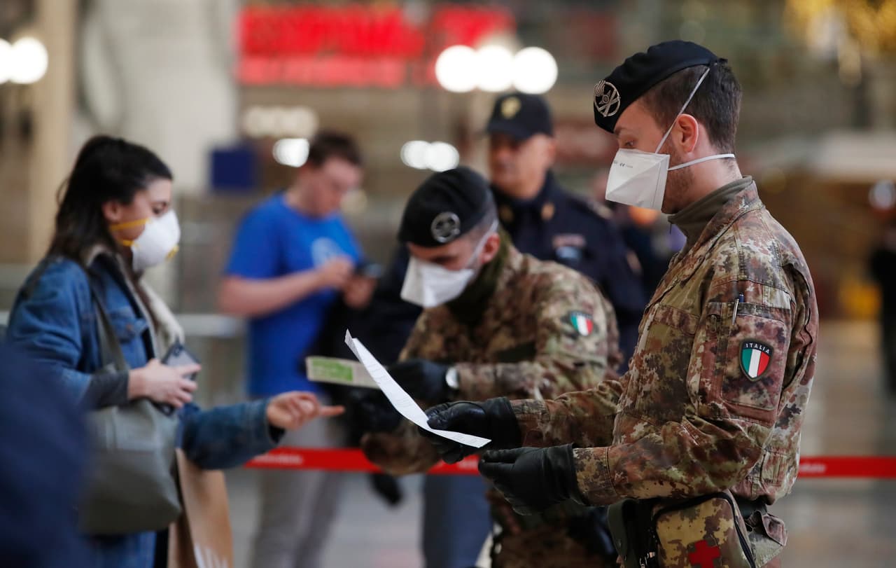 Oficiales de policía y soldados revisan a los pasajeros que salen de la estación principal de trenes de Milán. La enfermedad provocada por el coronavirus se acerca ya a la pandemia, según la Organización Mundial de la Salud (OMS).