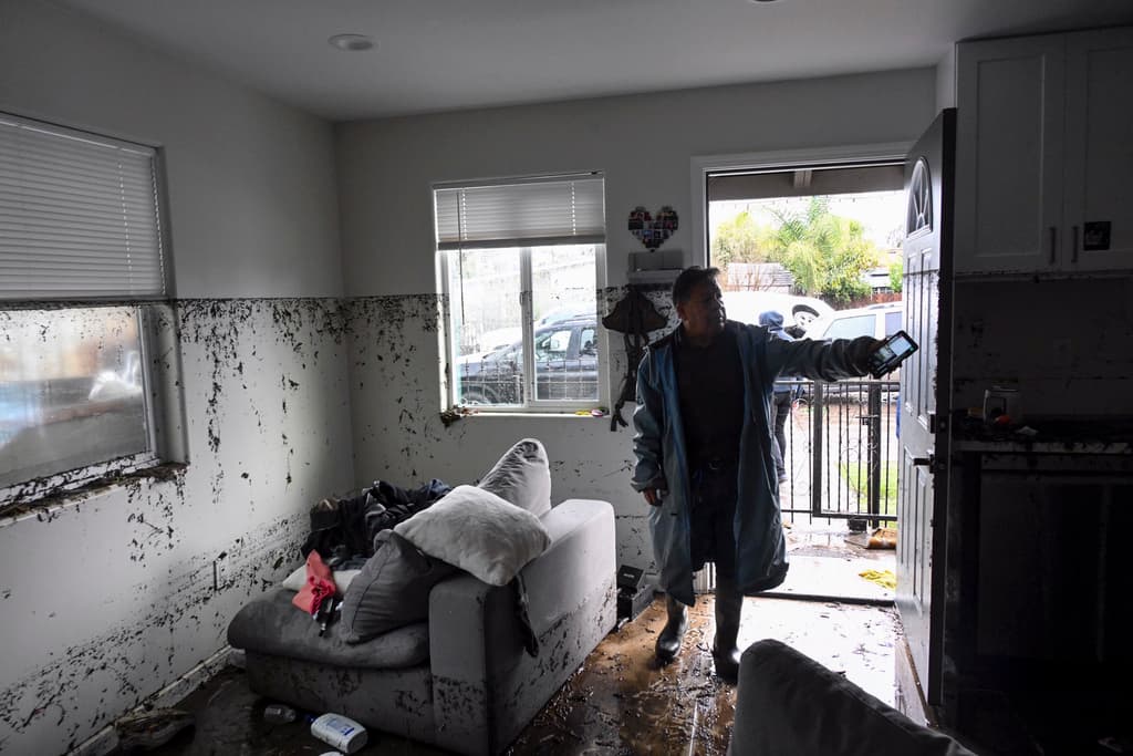 Tony Blas apunta hasta dónde llegó el agua al inundar su vivienda en San Diego.