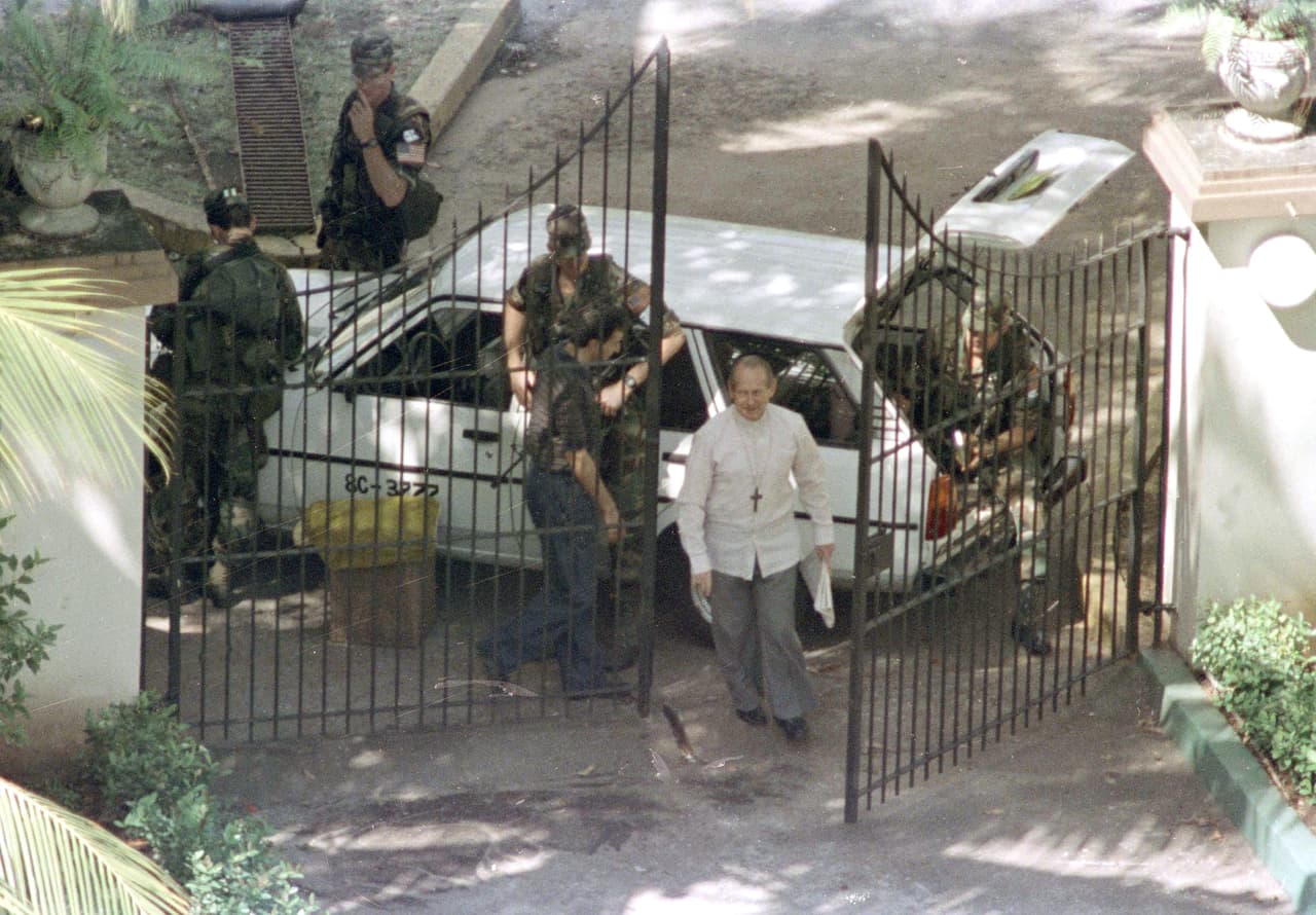El embajador del Vaticano, José Sebastián Laboa, cruza la puerta y pasa a los soldados estadounidenses hacia el complejo de la nunciatura en la ciudad de Panamá, el 1 de enero de 1990.