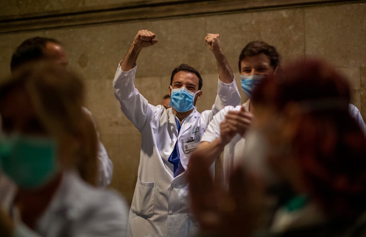 <b>Pequeñas victorias ante un monstruo (26 de marzo). </b>Trabajadores de salud de Barcelona, España, saludan victoriosos a las personas que los aplauden desde los balcones. Después de Italia, este país ha sido el más golpeado por la pandemia y en Madrid, la capital, los residentes en cuarentena asignaron un horario para agradecer a los médicos y enfermeros cada día.