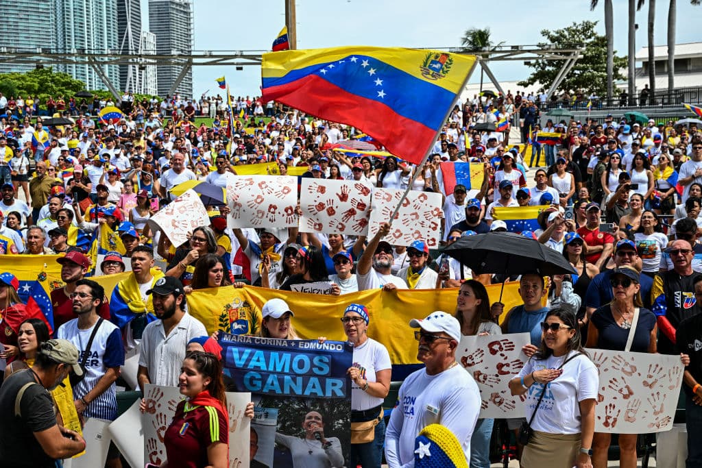 Autoridades de la ciudad, líderes opositores en el exilio, celebridades y voluntarios desfilaron por un escenario pintado de negro, con una pantalla gigante transmitiendo imágenes desde Caracas.