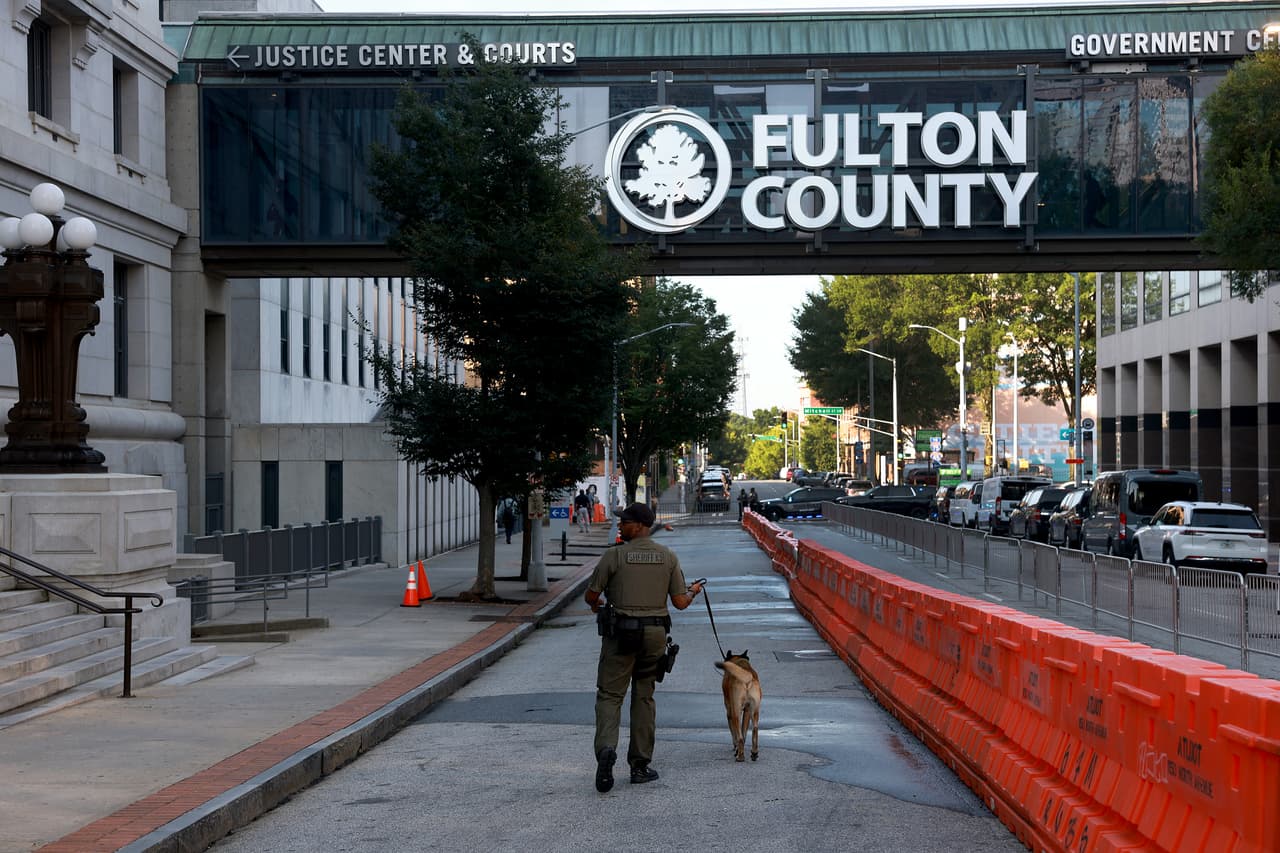 ATLANTA, GEORGIA - AUGUST 08: A Fulton County Sheriff K-9 officer secures the area around the Fulton County Courthouse on August 08, 2023 in Atlanta, Georgia. The heightened security is in place as Fulton County District Attorney Fani Willis is expected to announce soon a possible grand jury indictment in her investigation into former President Donald Trump and his Republican allies' alleged attempt to overturn the 2020 election in the state. (Photo by Joe Raedle/Getty Images)