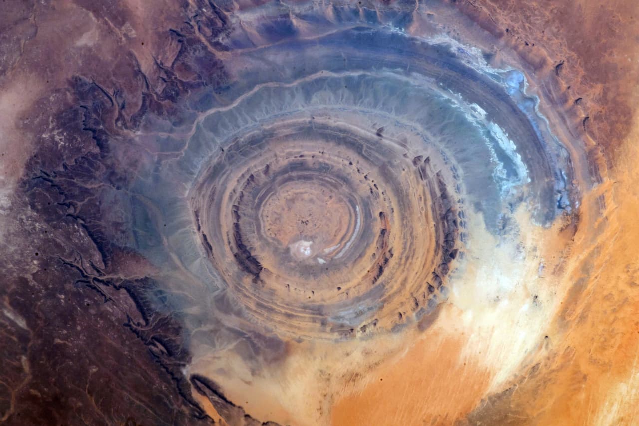 “La perspectiva hace toda la diferencia. Desde nuestra posición en la Estación Espacial, a 250 millas de distancia, la historia viva de la Tierra salta a la vista a través de los pliegues y marcas gigantes. Hay una peculiaridad geológica sorprendente y fácil de ver desde el espacio: el "Ojo del Sahara", escribió Hague junto a esta foto el 16 de septiembre. Esta peculiar formación geológica, también conocida como 
<a href="https://earthobservatory.nasa.gov/images/92071/richat-structure" target="_blank">Estructura de Richat</a>, sólo se puede ver en su totalidad desde el espacio. Tiene un diámetro de 30 millas y está ubicada en Mauritania, África.