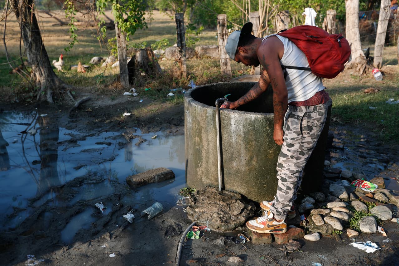 Un migrante centroamericano llena su botella de agua de un grifo en una granja de animales en Mapastepec. El sacerdote Heyman Vázquez, párroco en Huixtla, municipio de la misma ruta, dijo a AP que las razones por las que la solidaridad ha disminuido se debe a 
<b>"la campaña de discriminación y xenofobia que se está creando a través de las redes sociales y los medios que culpan a los migrantes de la inseguridad en Chiapas”.</b>