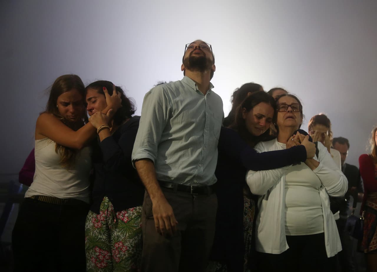 Familiares del periodista Marques se abrazan y lloran durante la misa. En total, 72 personas de las 77 que iban a bordo de la nave perdieron la vida en una zona montañosa de Antioquia, en el noroeste de Colombia. Al avión le restaban solo 17 kilómetros cuando cayó a tierra. (Foto de Pilar Olivares/Reuters)