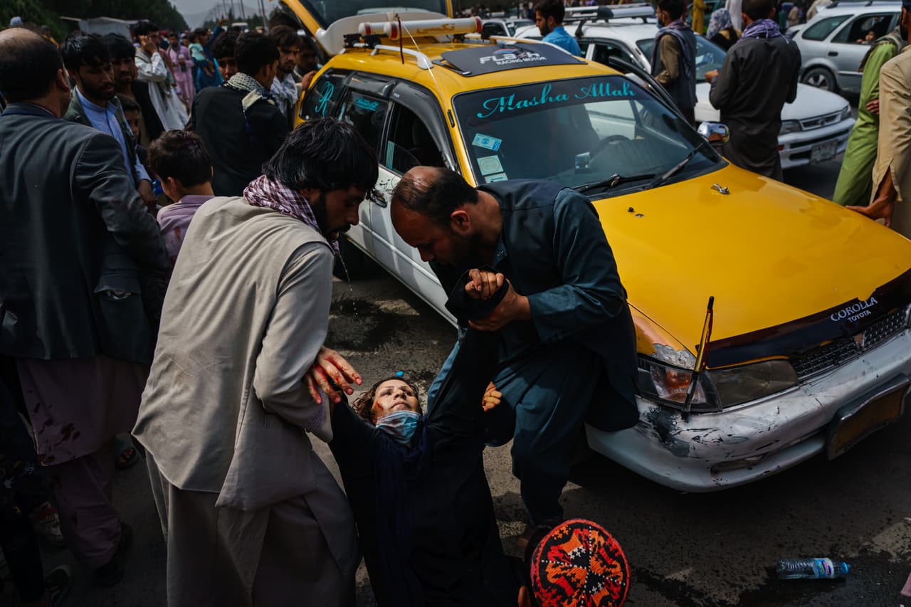 En medio de la incertidumbre, miles de afganos han tratado de huir del país, mientras Estados Unidos y sus aliados tratan con dificultad de poner orden en su retirada caótica. La fotografía del 17 de agosto muestra a varios hombres ayudando a una mujer y a su hijo heridos por combatientes talibanes que intentaban mantener el control de la multitud fuera del aeropuerto de Kabul.
<br>