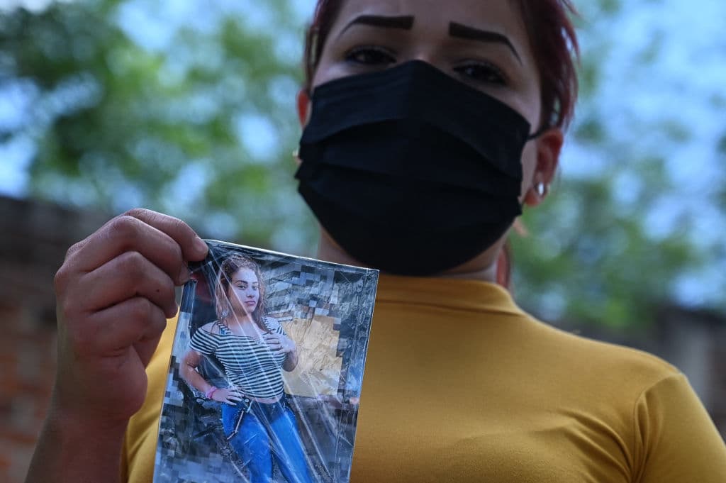 Una familiar de Camila Gabriela, quien desapareció, muestra su foto cerca de la casa del expolicía, donde las autoridades encontraron al menos 18 cadáveres.