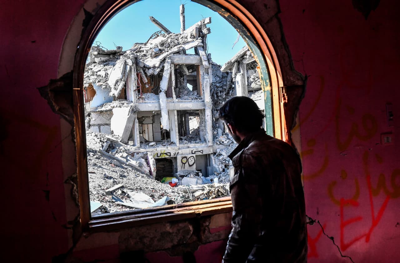 Un miembro de las Fuerzas Democráticas Sirias, quienes apoyados de EEUU expulsaron a ISIS de Raqqa, mira los restos de la ciudad desde la ventana de un edificio en la línea de fuego. La liberación de la ciudad es una nueva derrota para el grupo Estado Islámico, que ha ido perdiendo las conquistas territoriales que había logrado en los últimos años.