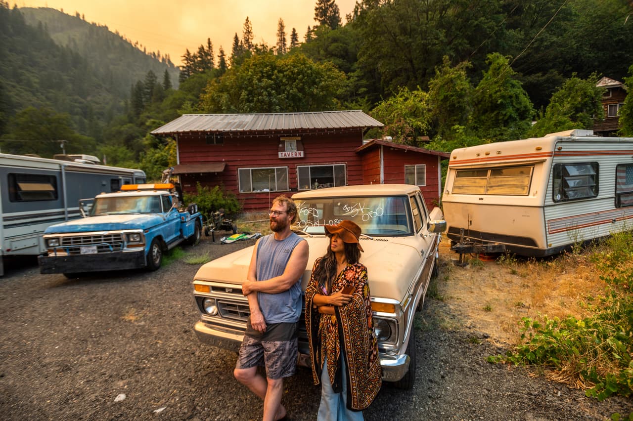 Jessica y Benjamin Bell observan cómo el incendio Dixie se incendia a lo largo de la autopista 70, en California.
