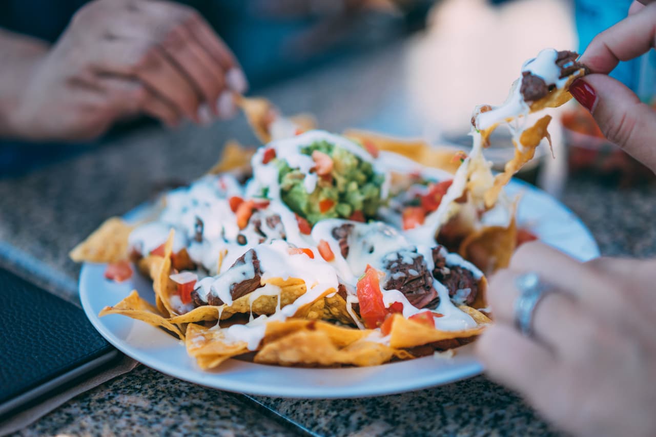 El plato se ha convertido en un clásico snack que cada quien lo prepara como quiere. En la imagen, nachos con queso, guacamole y frijoles.