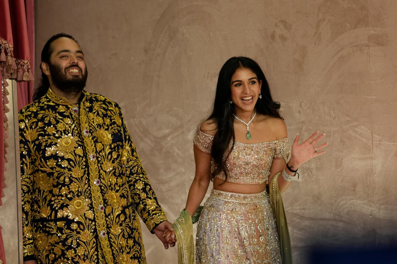 Anant Ambani, a la izquierda, y Radhika Merchant posan para los fotógrafos durante su ceremonia previa a la boda en Mumbai, India, el viernes 5 de julio de 2024. 
<br>
<br>La familia Ambani posee, entre otros activos, un complejo familiar de 27 pisos en Mumbai valorado en 1,000 millones de dólares. El edificio contiene tres helipuertos, un garaje para 160 autos y una sala de cine privada. 
<b>El novio, Anant, de 29 años, supervisa la expansión de energía verde y renovable del conglomerado.</b> También dirige un centro de rescate de animales de 3,000 acres (unas 1,200 hectáreas) en Jamnagar, en el estado de Gujarat, la ciudad natal de la familia.
<br>
