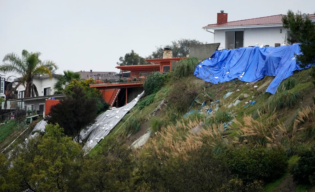 Con toldos plásticos, residentes en 
<b>Baldwin Hills</b>, al sur de Los Ángeles, intentaban este martes, 6 de febrero, que el terreno en el cual sus casas están cimentadas, no cediera aún más.