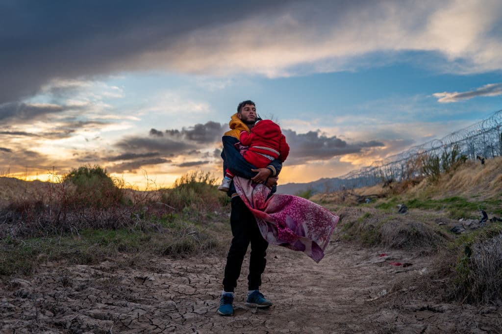 El migrante peruano Jordan y su hija de 1 año Briana esperan para cruzar a EEUU, el 26 de marzo, cerca de El Paso, Texas, mientras cientos de migrantes que buscaban asilo se enfrentaron con guardias texanos mientras buscaban entregarse a la patrulla fronteriza. 
<a href="https://www.univision.com/noticias/inmigracion/texas-gobierno-federal-puesta-marcha-ley-antiinmigrante-sb4-corte">La Ley Senatorial 4, la SB4 de Texas,</a> que permitía a fuerzas estatales arrestar migrantes por sospechas de cruces ilegales, se puso en vigor brevemente en esos días. Tras idas y vueltas legales, la ley antiinmigrante quedó suspendida.