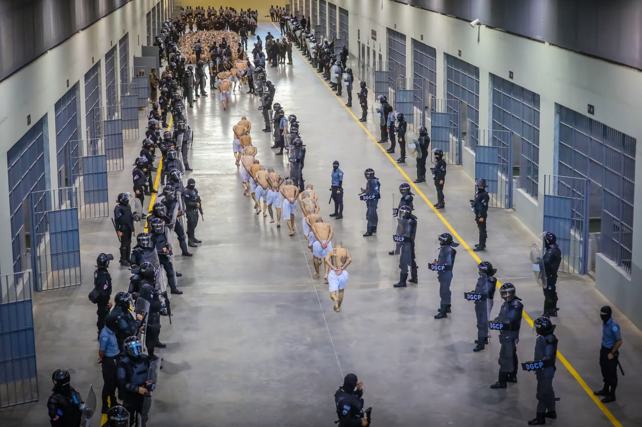 Los presos llegan al Cecot, de acuerdo con esta imagen distribuida por el gobierno salvadoreño. Bukele inauguró el Cecot a finales de enero y el ministro de Obras Públicas, Romeo Rodríguez, dijo al mandatario que esta "se constituiría en la cárcel más grande de toda América" y que "sería imposible que salga un reo" del recinto, que tiene 23 hectáreas de construcción.