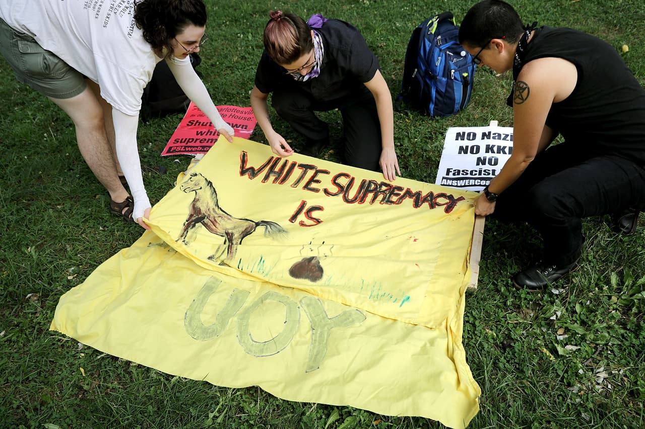 Manifestantes anti-fascistas preparaban sus pancartas hechas en casa antes del mitin de los supremacistas blancos.