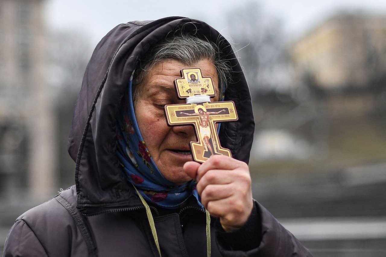 Una mujer reza en la céntrica plaza de la Independencia de Kiev, el día que empezó la invasión de Rusia. El Servicio Estatal de Emergencia de Ucrania informó que sus socorristas han conseguido salvar la vida de más de 150 personas, evacuar a otras 500 y sofocar más de 400 incendios provocados por los bombardeos rusos.
