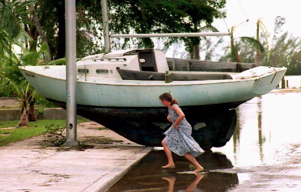 Según un estudio de la aseguradora Swiss Re, los daños que ocasionaría un huracán como Andrew si impactara en Miami en 2017, 
<b><a href="http://www.swissre.com/rethinking/climate_and_natural_disaster_risk/hurricane_andrew_20_miles_saved_miami.html">totalizan entre 100,000 millones y 300,000 millones de dólares</a></b>. En la fotografía, una mujer corriendo al frente de una lancha que quedó por fuera de una playa de South Beach.