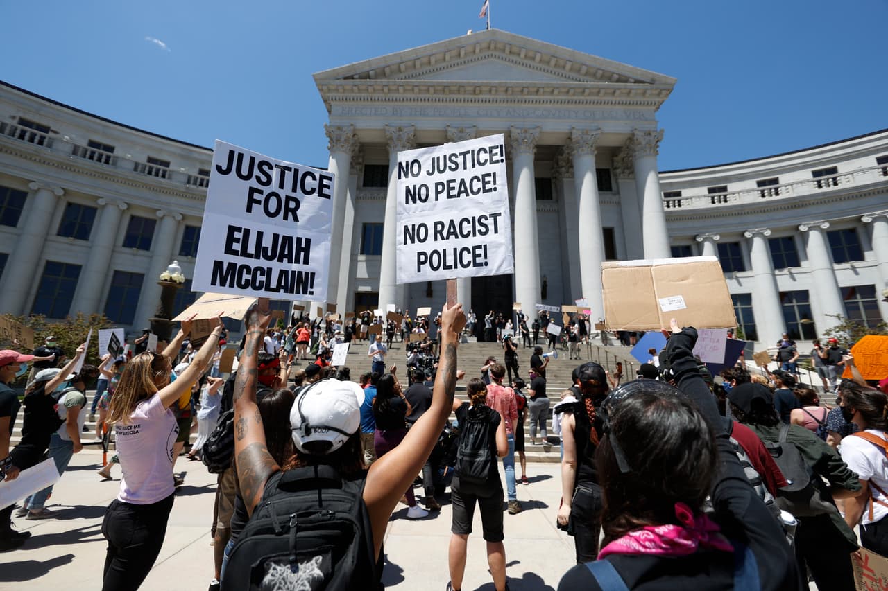 Participantes agitan pancartas durante una protesta afuera del ayuntamiento de Denver, Colorado, por la muerte de 
<a href="https://www.univision.com/noticias/estados-unidos/acusan-de-asesinato-al-expolicia-que-sometio-violentamente-a-george-floyd-y-le-causo-la-muerte">George Floyd</a>.