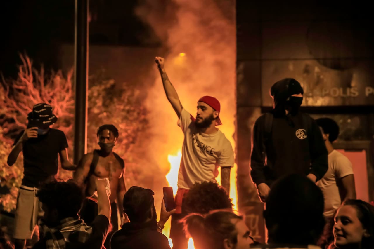 Los manifestantes rodearon el tercer precinto de la Policía de Minneapolis, donde rompieron ventanas, cargaron cercas, hicieron pintadas y encendieron fuego.