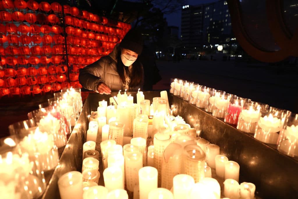 Una mujer enciende una vela en un templo Jogye durante las celebraciones de fin de año en Seúl, la capital de Corea del Sur. En Corea del Sur este fin de año ha habido restricciones por el covid-19, dada 
<a href="https://www.univision.com/noticias/coronavirus/covid-19-coronavirus-causa-estragos-en-china-hospitales-y-crematorios-desbordados">el alza descontrolada de casos que está viviendo la vecina China</a>.