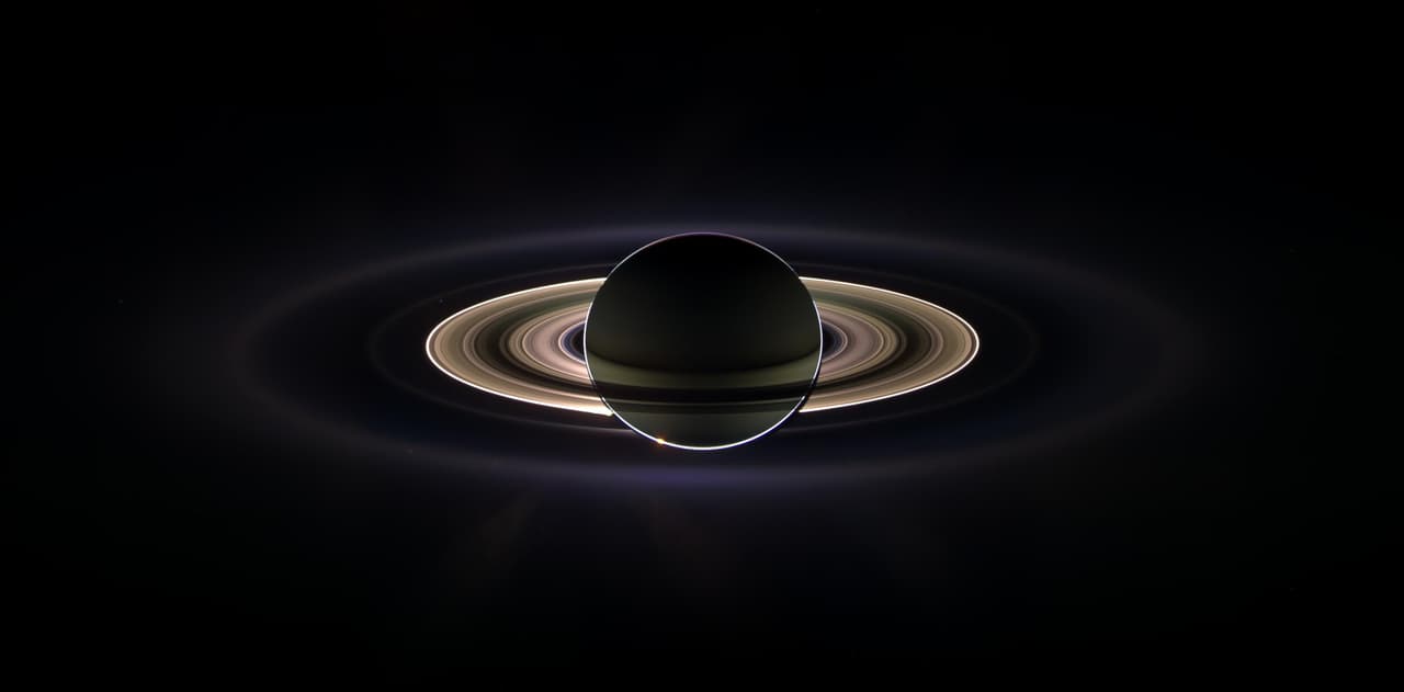 Esta maravillosa vista panorámica fue creada por la combinación de un total de 165 imágenes tomadas por la cámara de gran angular durante casi tres horas el 15 de septiembre de 2006. Con el gigantesco Saturno protegiendo a Cassini del resplandor cegador del sol, la nave espacial vio los anillos como nunca antes, revelando anillos desconocidos hasta ahora e incluso vislumbrando su mundo natal, la Tierra.