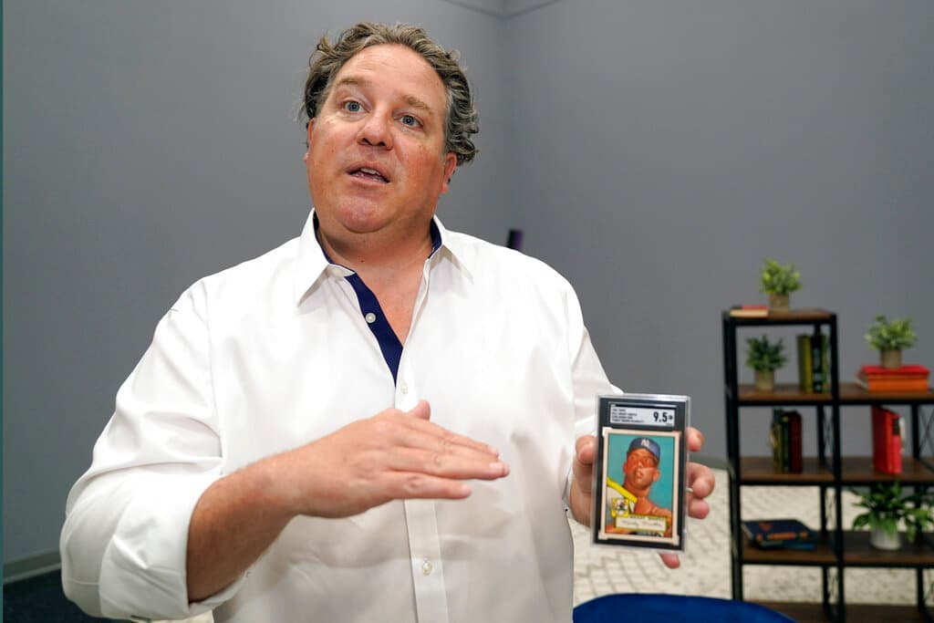 Chris Ivy, director de subastas deportivas de Heritage Auctions, sostiene y habla sobre una tarjeta de béisbol de Mickey Mantle en Dallas, el jueves 21 de julio de 2022.