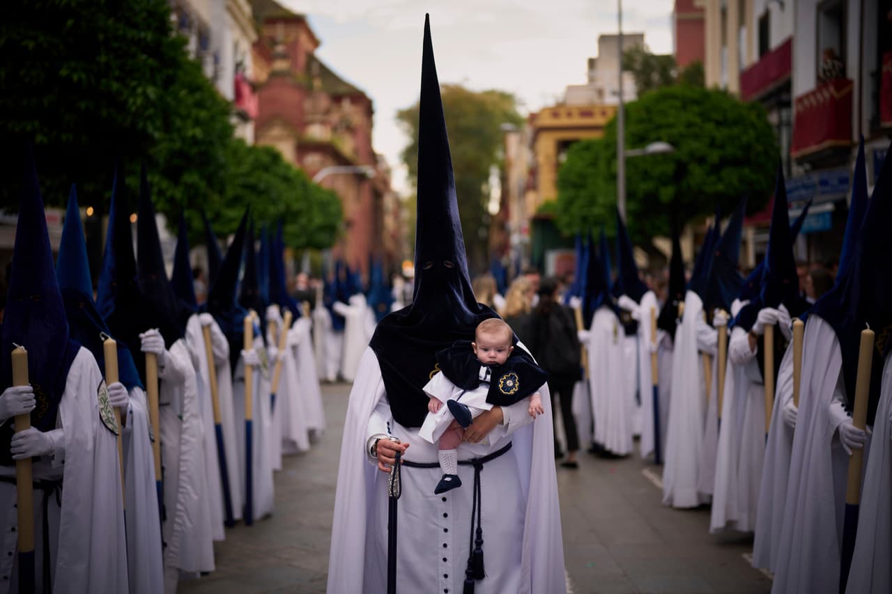 Un penitente sostiene a su hijo de seis meses durante una procesión de Semana Santa en Sevilla, España.
<br>
<br>Este año, 
<b>la coincidencia de fecha ha sido vista por algunos como una oportunidad para promover la unidad entre las iglesias cristianas. </b>El 
<b>Papa Francisco ha aprovechado la ocasión para renovar su llamado a establecer una fecha común para la Pascua, evocando el espíritu del Concilio de Nicea, que hace 1,700 años </b>reunió a líderes cristianos para resolver disputas fundamentales sobre la fe.
