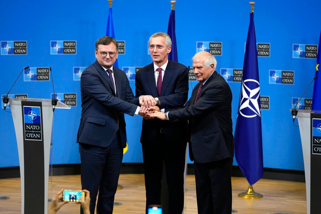 From left, Ukraine's Foreign Minister Dmytro Kuleba, NATO Secretary General Jens Stoltenberg and European Union foreign policy chief Josep Borrell join hands after addressing a media conference at NATO headquarters in Brussels, Tuesday, Feb. 21, 2023.