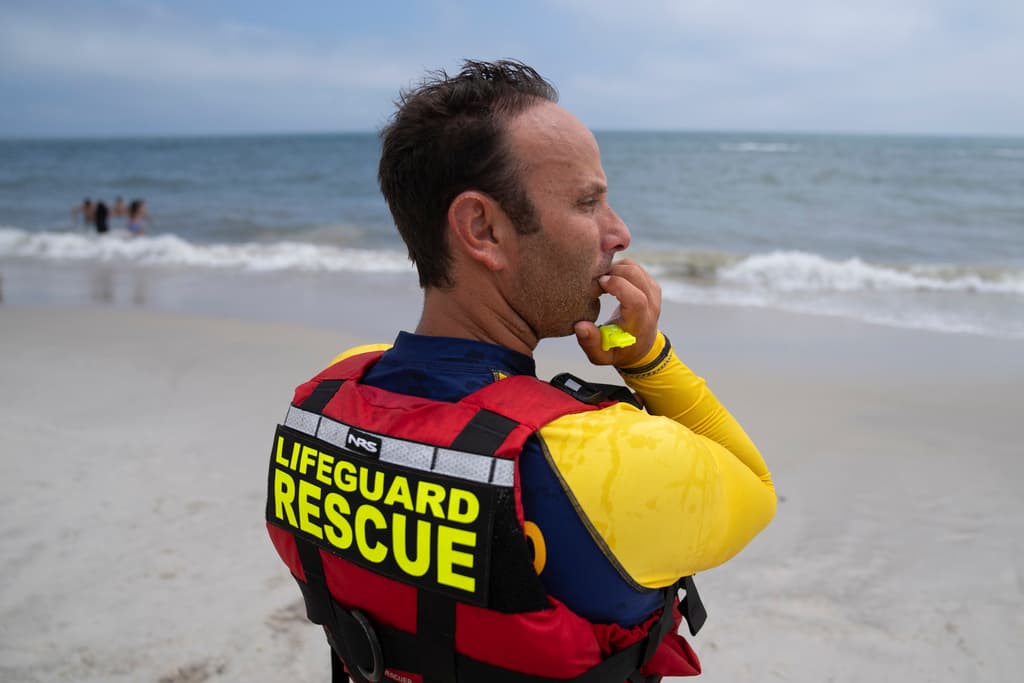Cary Epstein, supervisor de salvavidas, monitorea la playa mientras sus colegas realizan un patrullaje de tiburones en una moto acuática en el Parque Estatal Jones Beach.