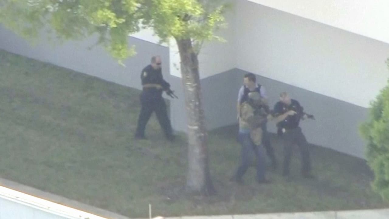 Policias armados en una de las puertas de la secundaria Marjory Stoneman Douglas. El evento comenzó a las 2:00 pm hora local.