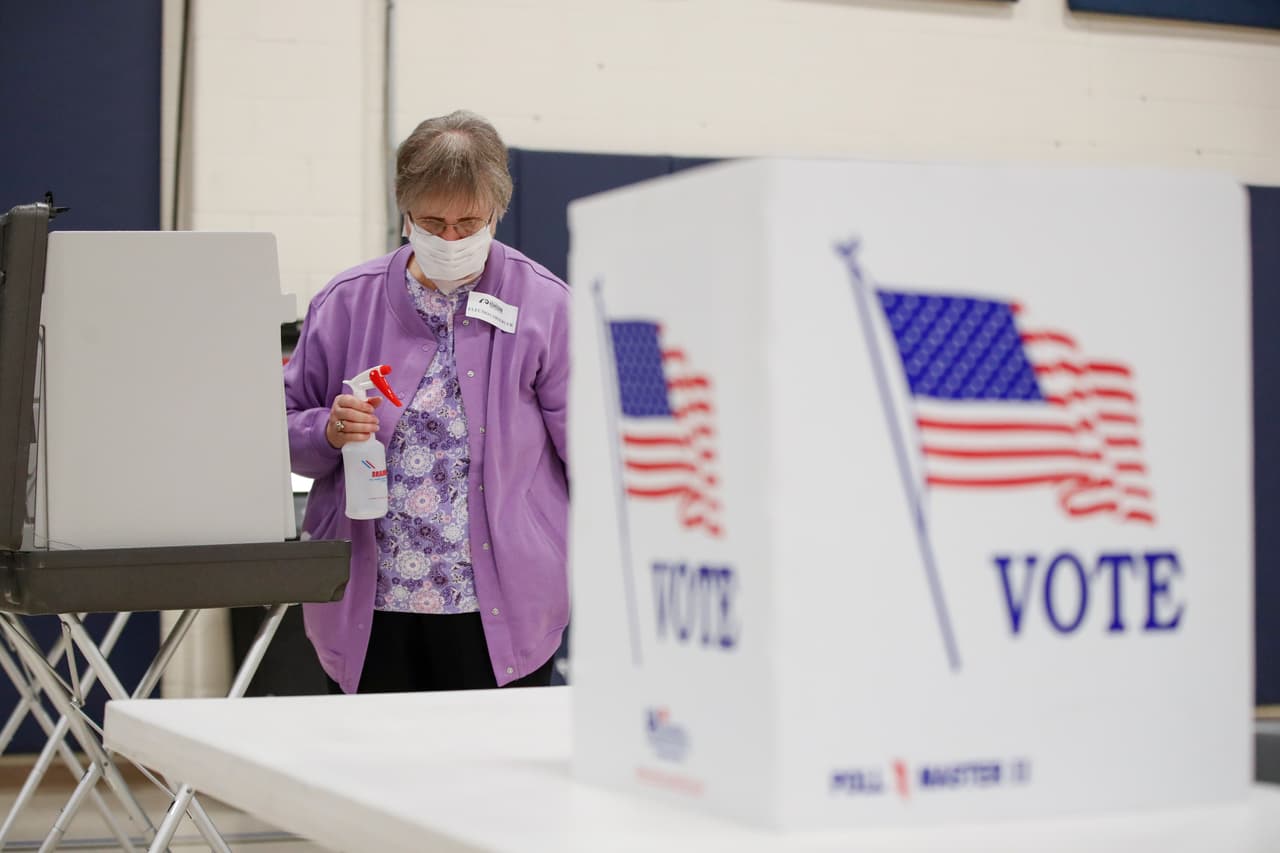 Un observador electoral limpia las mesas de votación en una iglesia de Kenosha, al sur de Wisconsin. Se prevé que los centros de votación cierren a las 8 de la noche, pero no se esperan resultados este día.
