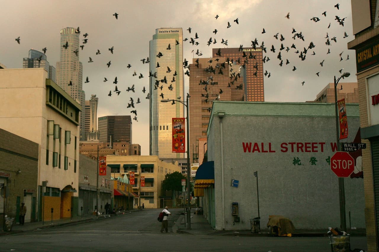 LOS ANGELES, CA - OCTOBER 12: Birds fly overhead in the Wall Street area where the homeless have waken up before dawn to dismantle their beds and encampments before businesses open October 12, 2007 in the downtown Skid Row area of Los Angeles, California. Los Angeles city officials recently settled a 2003 lawsuit brought by advocates for homeless skid row residents who complained of being arrested for sleeping on sidewalks, despite having nowhere else to go. Under the new deal, people can sleep on Los Angeles sidewalks between 9 p.m. to 6 a.m. as long as they do not block doorways or driveways, or completely block the sidewalk. Los Angeles is often referred to as the homeless capital of the nation because of its estimated 40,144 people living on city streets and 73,000 homeless spread across the county, according to recent figures attributed to the Los Angeles Homeless Services Authority, The 73,000 homeless include 10,000 minors, 24,505 people suffering from a mental illness, 8,453 military veterans, and nearly 7,200 victims of domestic abuse. (Photo by David McNew/Getty Images)