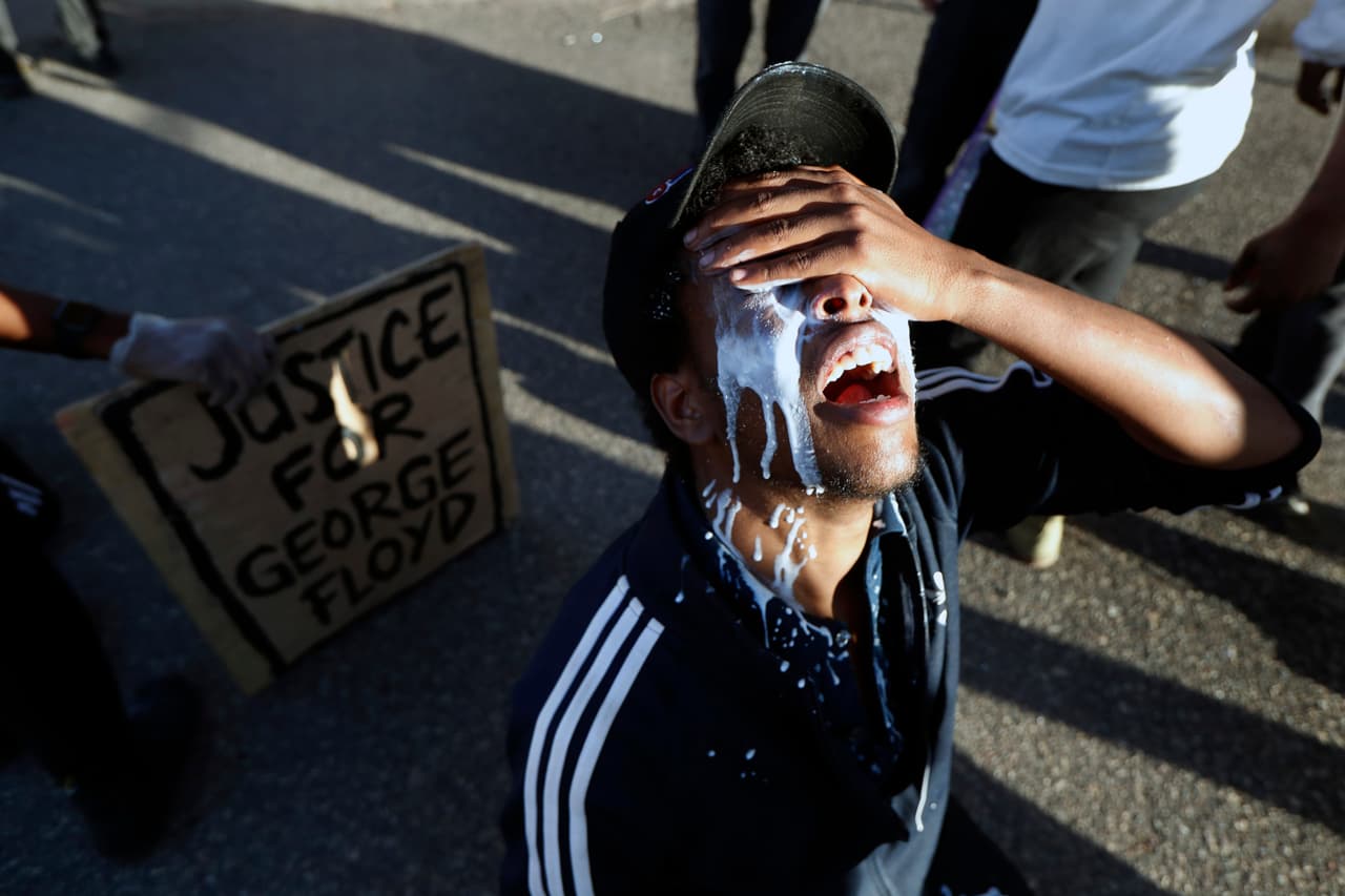 En Minneapolis, Minnesota, durante las protestas por la muerte de George Floyd, un hombre con la cara empapada de leche yace de rodillas en la calle tras ser rociado con gas pimienta, a medida que las protestas se fueron haciendo violentas.