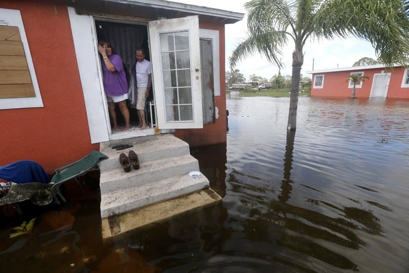 Quintana and Liz Perez look at the flooding outside their home in the aftermath of Hurricane Irma, in Immokalee, Fla, one of the poorest towns in the state. Home of many day laborers and migrant workers, Immokalee sustained heavy damage from Irma that will take months to overcome. (AP Photo/Gerald Herbert)