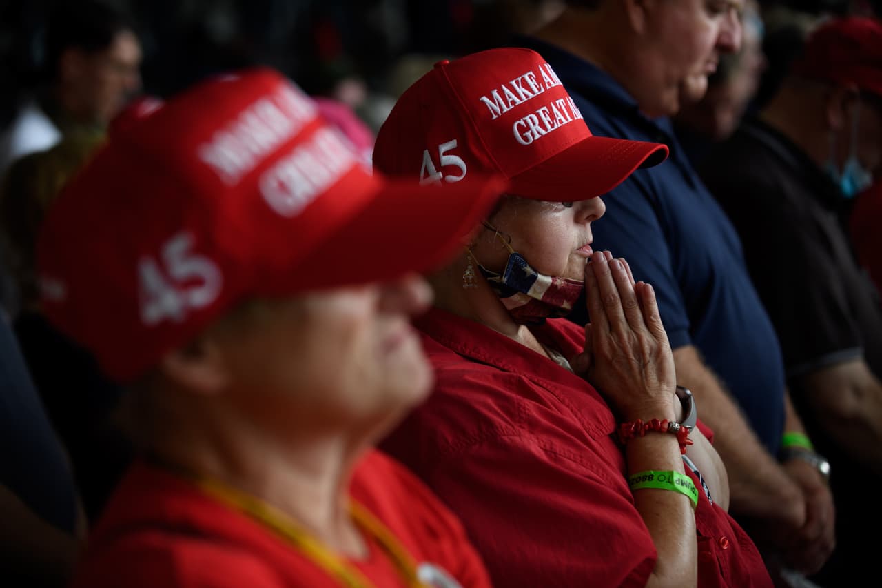 Los partidarios de Trump oran mientras esperan su llegada al aeropuerto de Latrobe. El presidente ha cosechado apotos entre algunos grupos evangélicos.