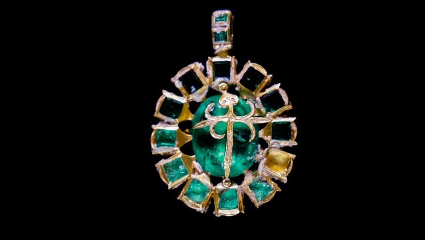 En la imagen, un dije de oro que contiene una esmeralda colombiana al centro, una docena de esmeraldas más pequeñas alrededor, que se cree que pueden representar a los 12 apóstoles de Cristo, y al centro con una cruz de St. James. 
<b>La pieza perteneció a la Orden de Santiago</b>, una orden religiosa y militar con siglos de antigüedad.